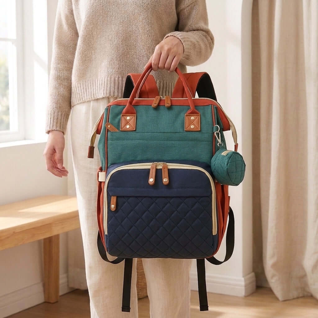 Red Colorblock Diaper Backpack held by a person, showcasing style and functionality for parents on the go.